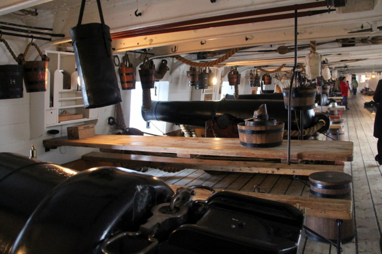 Inside HMS Warrior, Portsmouth Historic gun deck inside HMS Warrior, with wooden tables and naval guns