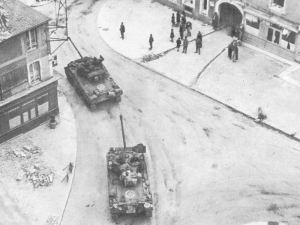 American Firefly tanks roll through a Normandy town